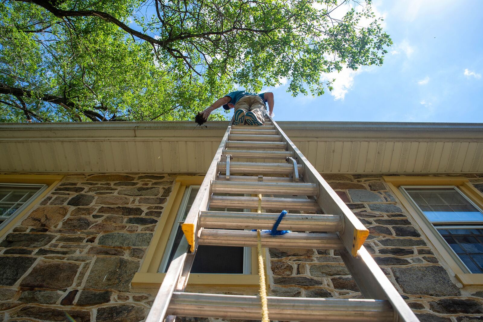 Lifetime Gutter Guards technician cleaning out a home's gutters