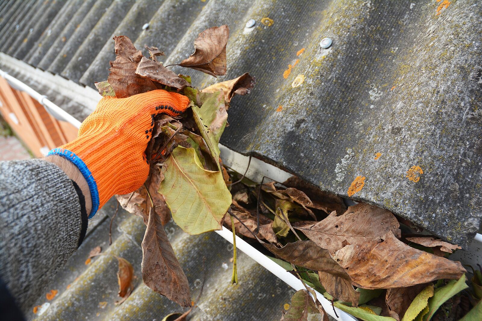 Technician performing a full gutter cleaning before guard installation