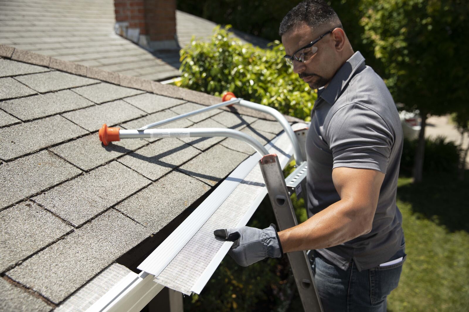 Installer connecting gutter guard sections at the roofline