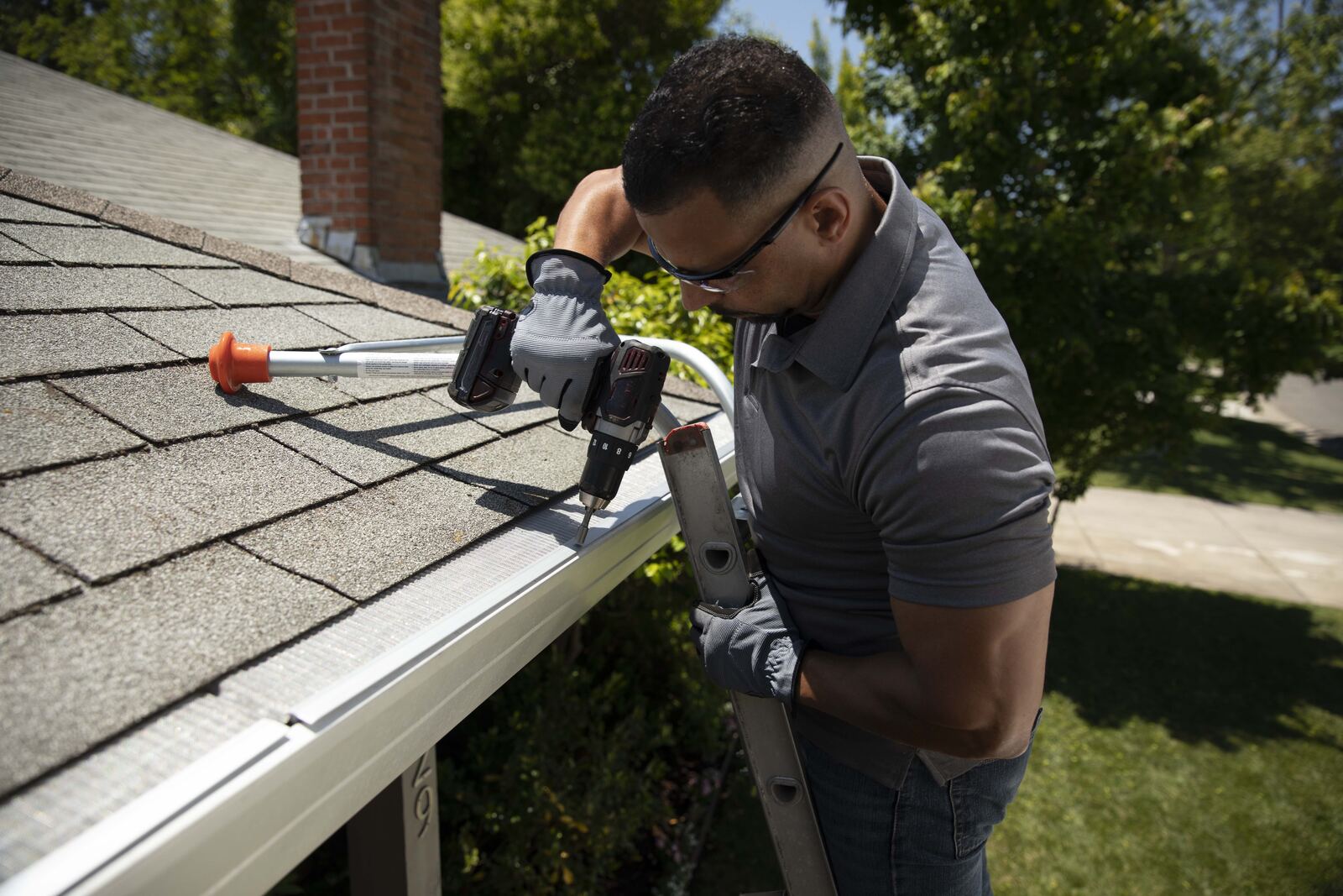 Installer fastening micro-mesh gutter guard with screws